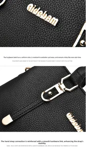 Detail of black lychee grain leather handbag with gold hardware and logo branding