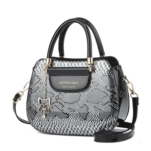 Elegant black snakeskin pattern tote bag with gold hardware and cat pendant charm