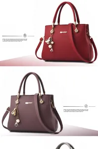 Detail of wine red and purple litchi grain leather handbags with pearl charms