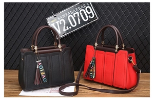 Détail de sacs à main en cuir grainé avec finitions dorées et pendentif LOVE à franges