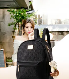 Detail of black backpack with 3D geometric circular texture and gold zipper hardware