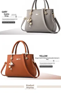 Close-up of grey and yellow-brown lychee leather handbags with floral metal charms
