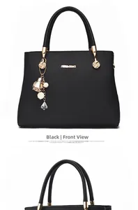 Detail shot of black litchi pattern leather handbag with gold logo and pearl charm