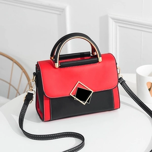 Sac à bandoulière contrasté rouge et noir élégant avec boucle géométrique dorée
