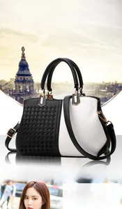 Detail of two-tone handbag featuring woven black leather and white pebble texture finish