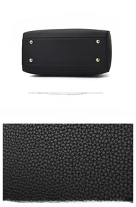 Macro view of lychee pattern PU leather and golden protective feet on black handbag