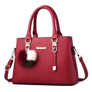 Red lychee pattern faux leather handbag with pompom charm and golden logo hardware