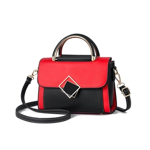 Sac à bandoulière contrasté rouge et noir avec boucle dorée et poignée en métal