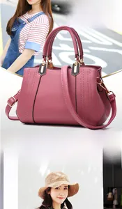 Detail showing dusty pink handbag with textured leather, stitching and gold hardware
