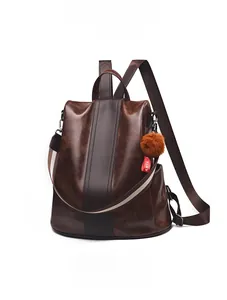 Detail view of coffee brown PU leather backpack with vintage texture and plush pendant