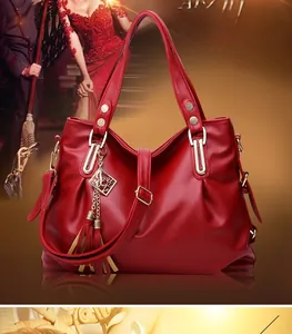 Detailed view of red tote bag featuring lychee texture and golden metal tassels