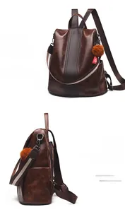 Detail view of brown vintage leather backpack with anti-theft zipper and pompom charm