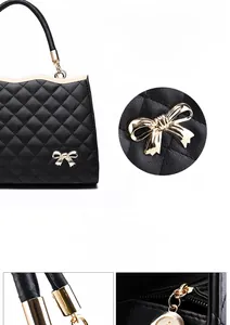 Details der schwarzen gesteppten Handtasche mit goldener Schleife und Metallgriff