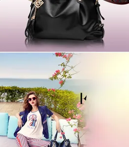 Detail of black lychee grain leather handbag with gold hardware and tassel charm