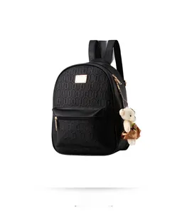 Detail view of mini black backpack with geometric texture and cute teddy bear charm