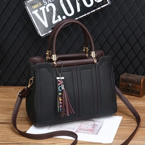 Sac fourre-tout chic en cuir grainé noir avec bordure marron et breloque à glands