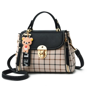 Women's plaid crossbody bag with black flap, gold twist lock, and a cute bear charm