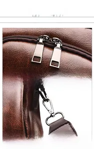 Detail of soft brown pebble leather backpack showing dual zippers and metal hardware