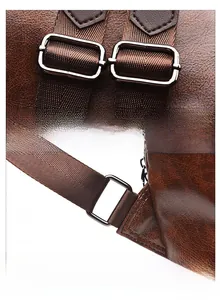 Detail of durable metal buckle and adjustable brown woven strap on a retro leather backpack