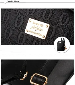 Detail of textured black leather backpack featuring gold branding plate and adjustable buckle