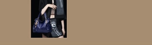 Detail of dark blue soft faux leather handbag with gold hardware and tassel charm