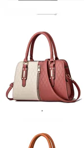 Detail of color-block tote bag with geometric texture and elegant gold hardware accents