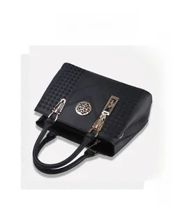 Close-up of black lychee grain leather handbag with woven detail and golden round logo