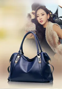 Detail of high-end hardware and lychee textured leather on a dark blue handbag