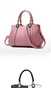 Detail view of pink and black lychee leather handbags with stitching and gold hardware