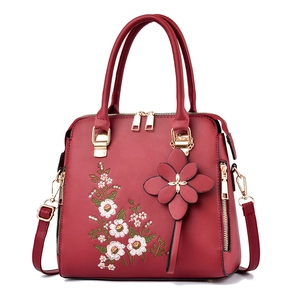 Elegant dark red embroidered handbag with floral pattern and golden metal hardware
