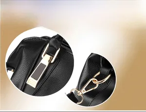 Detail of golden hardware buckles and strap hooks on black pebbled leather handbag