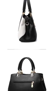 Detail view of contrast stitching and gold hardware on side of black and white tote bag