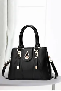 Détail d'un sac à main en cuir noir avec des finitions dorées et un fermoir de haute qualité
