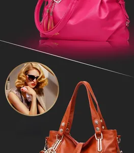 Detail of red-brown leather handbag with litchi grain texture and tassel charm