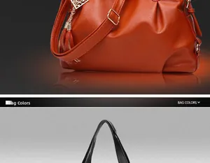 Detail view of large soft leather handbags in orange and black with tassel charm