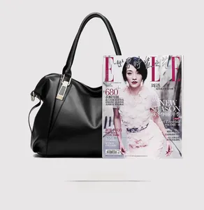 Detailed view of black litchi pattern leather tote bag compared with a magazine size