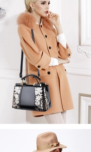 Detail of black patent leather bag with gold sequin floral embroidery and top handle