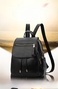 Detail of black pebbled leather backpack with gold zipper and drawstring closure