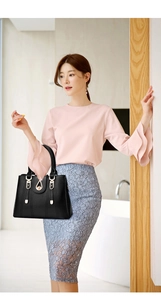 Sac à main élégant en cuir noir avec boucle dorée assorti à une tenue professionnelle chic