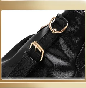 Detailed close-up of high-quality textured black leather bag with gold metal ring buckles