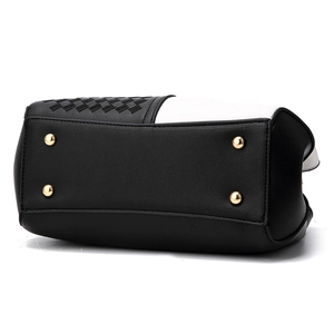 Bottom view of black and white leather handbag with golden protective metal rivets