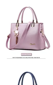 Detail view of taro purple textured handbag featuring Aimily metal logo and tassel charm