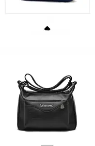 Detail view of the soft lychee grain leather texture and metallic zipper on a black handbag