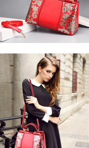 Detail of red patent leather handbag with floral embroidery and detachable shoulder strap