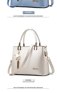Close-up of sky blue and beige leather handbags with gold hardware and tassel details