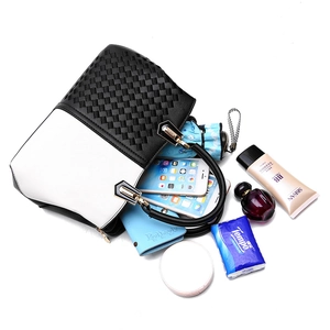 Chic black and white color-block tote bag with woven texture and gold metal hardware
