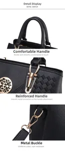 Detail of black pebbled leather handbag with gold zippers and reinforced handles