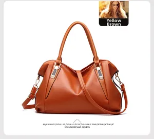 Detail of yellow-brown soft leather tote bag with reinforced handles and gold hardware