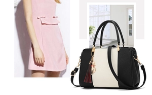 Detail of contrast stitching, black lychee leather, and gold cat pendant on handbag