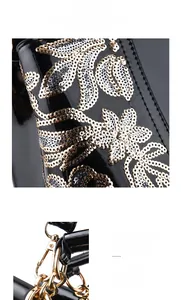 Detail of black patent leather handbag with gold hardware and floral sequin embroidery